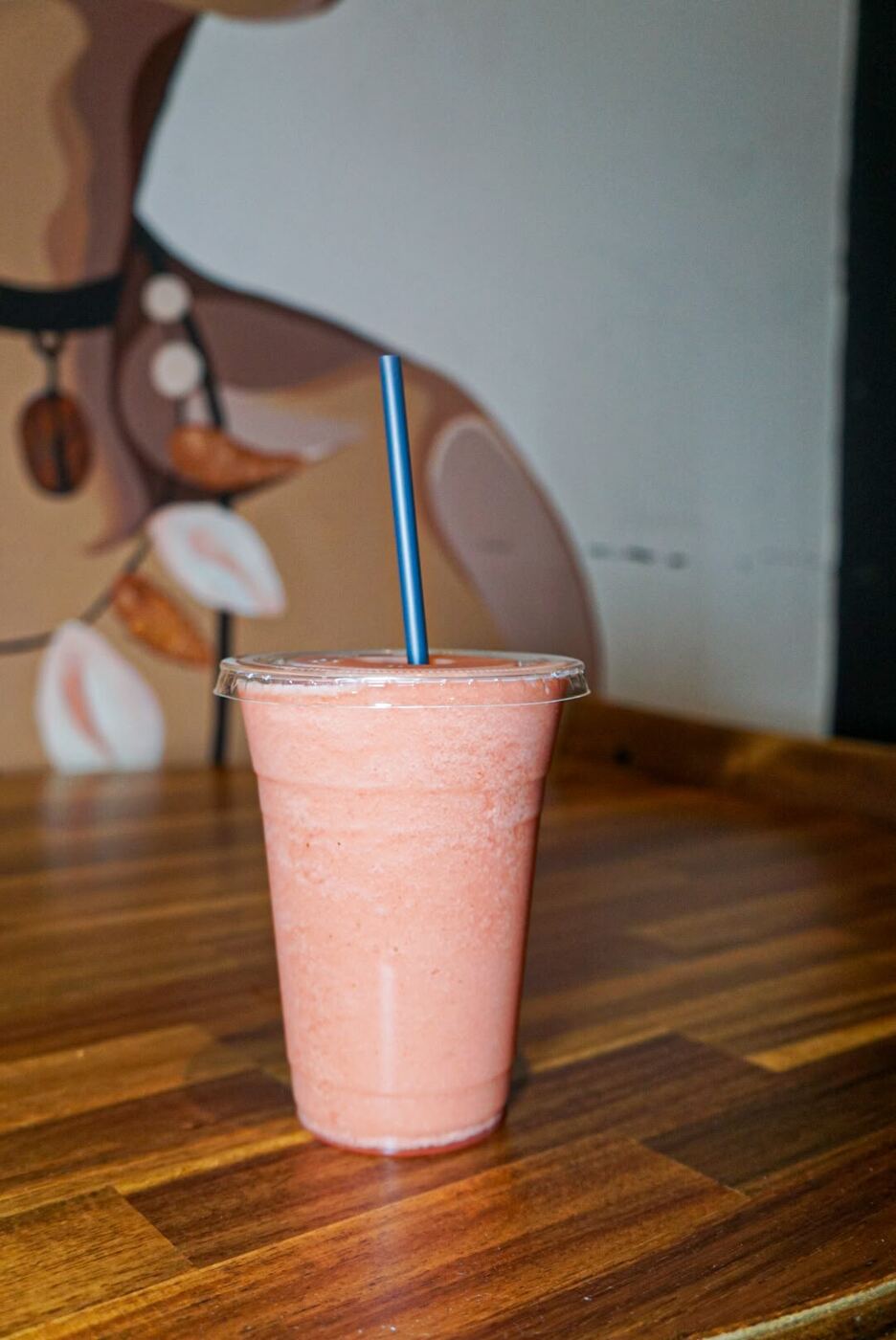 Batida de fresa frente al mural de El Cafecito